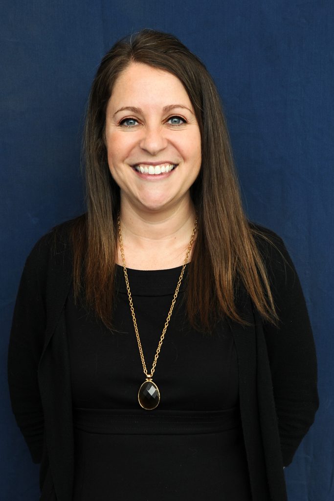 Picture of Abby Braitman, Ph.D. with a dark blue background.