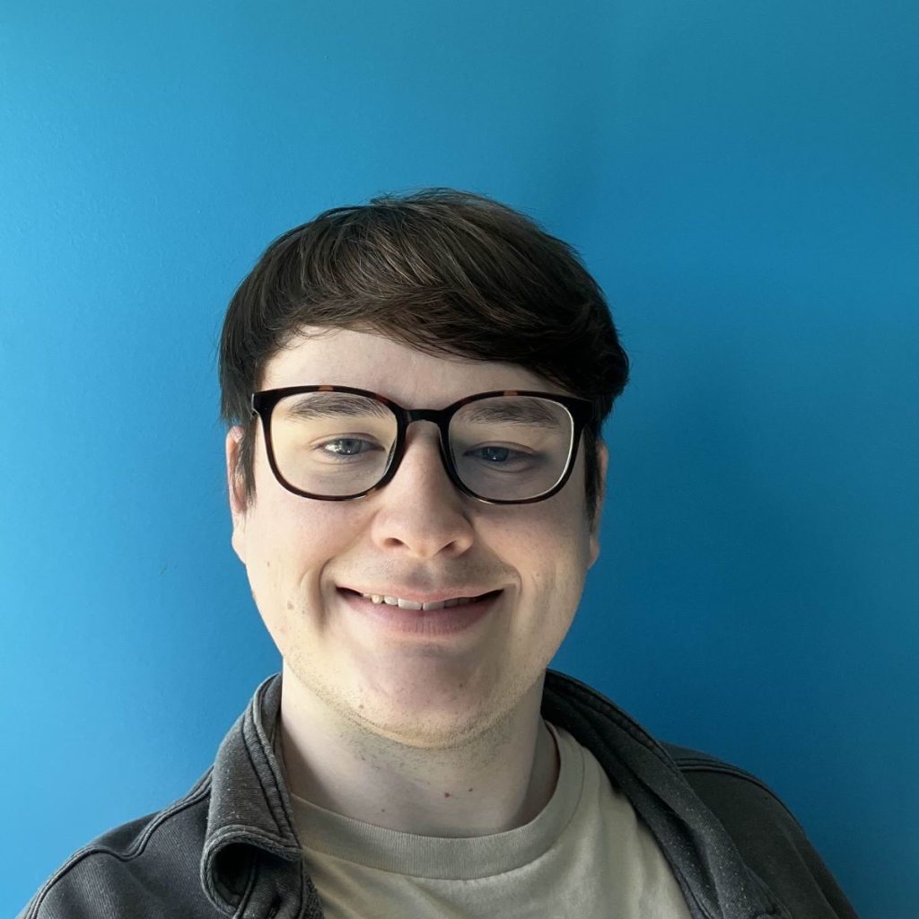 A person with glasses smiling, set against a bright blue background.
