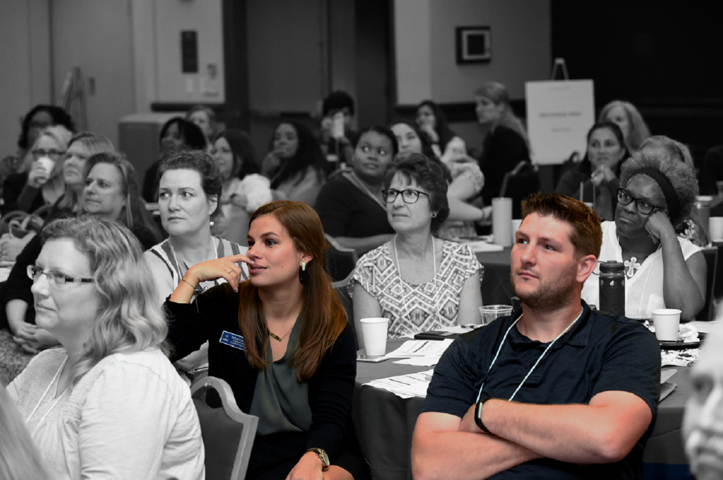 conference attendees at a table watching off camera conference attendees at a table watching off camera