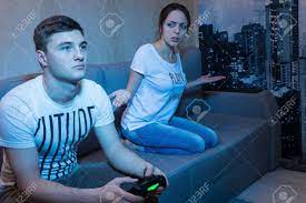 Young Man Playing A Video Game Watched By His Frustrated Wife.. Stock Photo, Picture And Royalty Free Image. Image 59215563.