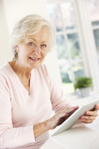 A woman using a tablet and smiling